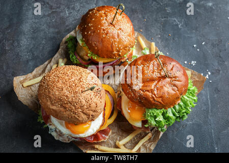 Leckere Burger mit Spiegelei auf Tisch Stockfoto