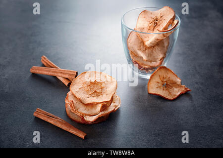 Zusammensetzung mit leckeren Apfel Chips und Zimt auf Tabelle Stockfoto