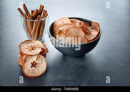 Zusammensetzung mit leckeren Apfel Chips und Zimt auf Tabelle Stockfoto