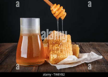 Zusammensetzung mit leckeren Waben und Pendelarm auf hölzernen Tisch Stockfoto