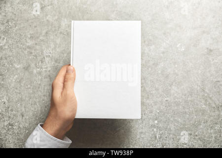 Mann, Buch mit Abdeckung auf grauem Hintergrund. Mock up für Design Stockfoto