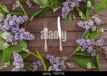 Die Einrichtung der Blumen von Maiglöckchen und Flieder auf dem Hintergrund der vintage Holzbretter. Vintage Hintergrund mit Rahmen von Blumen und pl Stockfoto