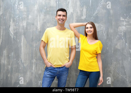 Junge Frau und Mann im gelben T-Shirts auf grunge Hintergrund. Mockup für Design Stockfoto