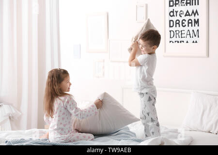 Süße Kinder Kissenschlacht im Bett zu Hause Stockfoto