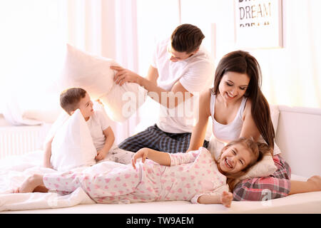 Happy Family in Kissenschlacht im Bett zu Hause. Stockfoto