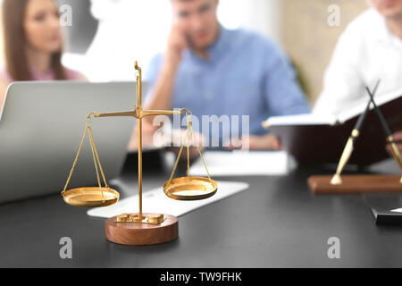 Waage der Gerechtigkeit auf Tisch in der Kanzlei Stockfoto