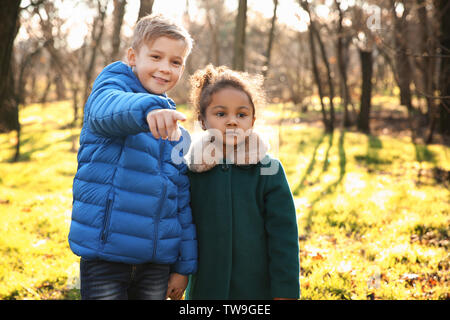 Cute Boy und afroamerikanischen Mädchen im Freien an einem sonnigen Tag. Kind Annahme Stockfoto