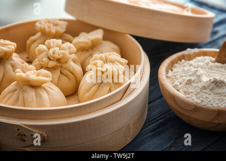 Lecker baozi Knödel in Bambus Steamer auf Tisch Stockfoto