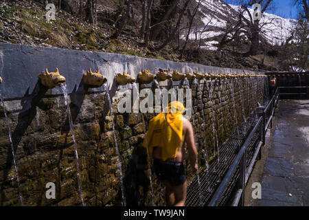 Muktinath Tempel, heilige sowohl Hindus und Buddhisten, Nepal. Bild zeigt Menschen zu Fuß unter Wasser Brunnen bei den Tempel als ein religiöser Ritus Stockfoto