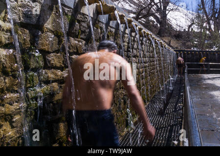 Muktinath Tempel, heilige sowohl Hindus und Buddhisten, Nepal. Bild zeigt Menschen zu Fuß unter Wasser Brunnen bei den Tempel als ein religiöser Ritus Stockfoto