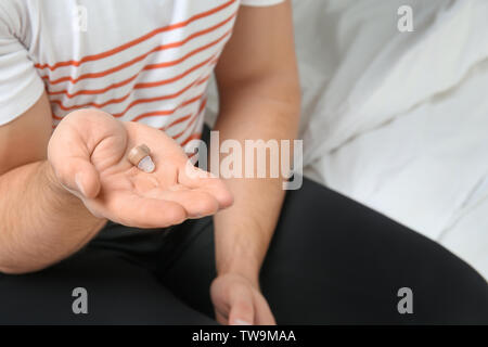 Junger Mann mit Hörgerät im Innenbereich Stockfoto