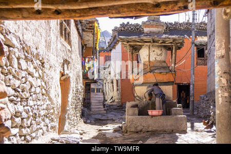 Eine Frau, die Wäsche waschen in den Brunnen in Kagbeni, Upper Mustang, Nepal Stockfoto