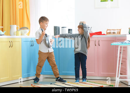 Süße kleine Kinder spielen mit Küchenutensilien zu Hause
