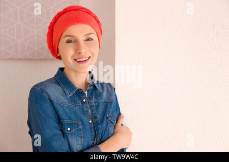 Junge Frau mit Krebs im Kopftuch im Innenbereich Stockfoto