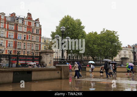 Die Leute gehen weg, das British Museum und in Richtung Tor und Exit gehen, im Regen, in Bloomsbury, London, Vereinigtes Königreich. Stockfoto