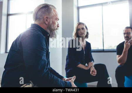 Ältere Unternehmer beraten, um sein Team in einem Büro treffen. Business Team zusammen zu sitzen und zu diskutieren. Stockfoto