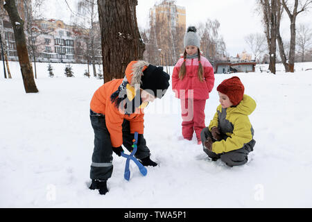 Kinder spielen in den verschneiten Park im Winterurlaub Stockfoto