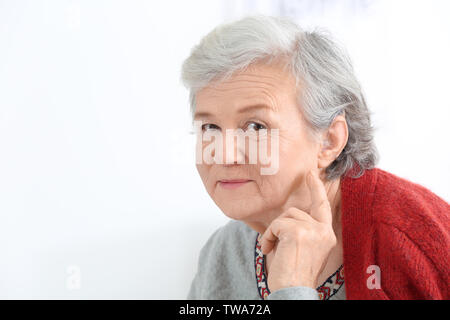 Reife Frau mit Hörgerät im Innenbereich Stockfoto
