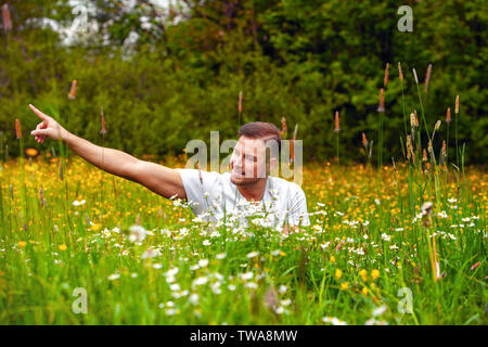 Entspannt junger Mann sitzt in einem Blume Stockfoto