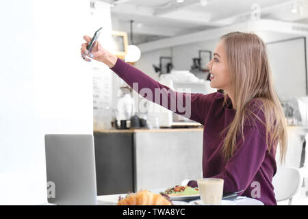 Junge Frau von selfie im Cafe Stockfoto