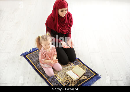 Muslimische Frau mit ihrer Tochter zu Hause beten Stockfoto