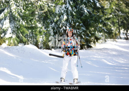 Frau mit Skilift am verschneiten Resort. Winterurlaub Stockfoto