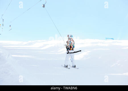 Frau mit Skilift am verschneiten Resort. Winterurlaub Stockfoto