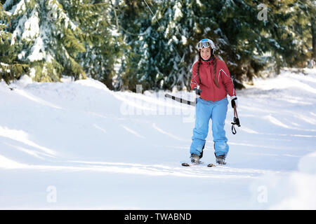 Frau mit Skilift am verschneiten Resort. Winterurlaub Stockfoto