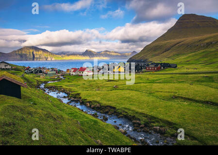 Dorf Gjogv auf den Färöer Inseln mit bunten Häusern und einem Creek