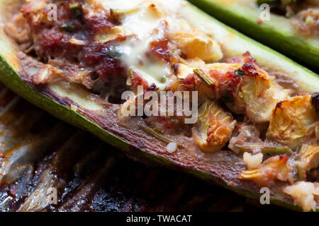 Gefüllte Zucchini mit Käse, überbacken mit Mozzarella. Gebackene gefüllte Zucchini. Zucchini Hälften gefüllt mit Hackfleisch/Faschiertem Stockfoto