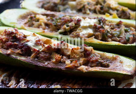 Gefüllte Zucchini mit Käse, überbacken mit Mozzarella. Gebackene gefüllte Zucchini. Zucchini Hälften gefüllt mit Hackfleisch/Faschiertem Stockfoto