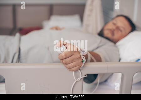 Mann in einem Krankenhaus als Krankenschwester. Eine Hand mit Not-Aus-Knopf im Krankenhaus Zimmer. Not-Aus-Taster für Patienten im Krankenhaus Stockfoto