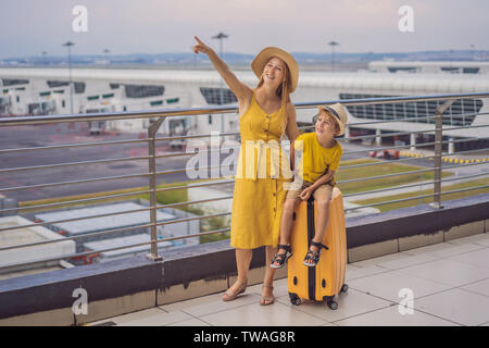 Familie am Flughafen vor dem Abflug. Mutter und Sohn warten an Bord am Abflugsteig des modernen internationalen Terminal. Reisen und fliegen mit Stockfoto