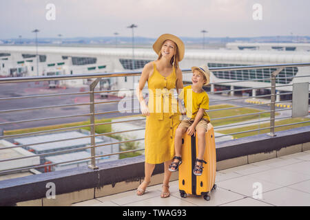 Familie am Flughafen vor dem Abflug. Mutter und Sohn warten an Bord am Abflugsteig des modernen internationalen Terminal. Reisen und fliegen mit Stockfoto
