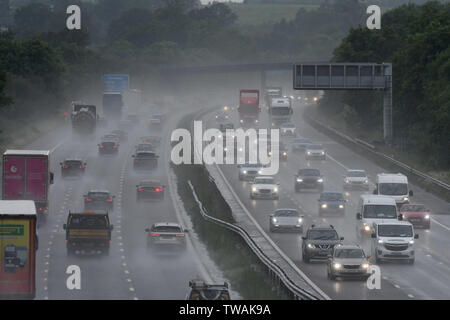 Abendlichen Hauptverkehrszeit Pendler fahren Sie durch schwere Regenfälle und Spray auf die Autobahn M40 in der Nähe von Chesterton, Warwickshire, Großbritannien. Juni 18, 2019. Stockfoto