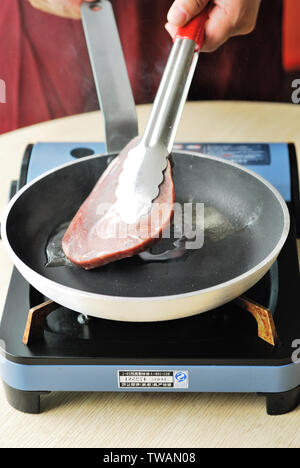 Das steak Braten in der Pfanne. Stockfoto