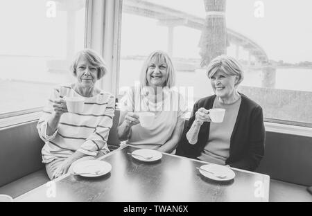 Freudige ältere Freunde in Tee oder Kaffee zusammen. Ältere Freundinnen plaudern, lachen und Spaß haben im Coffeeshop in Bleiben Sie aktiv im Ruhestand Stockfoto