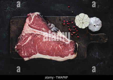 Frische rote T-Bone Steak Roh trocken Rindersteaks auf Vintage Brown Schneidebrett Stockfoto