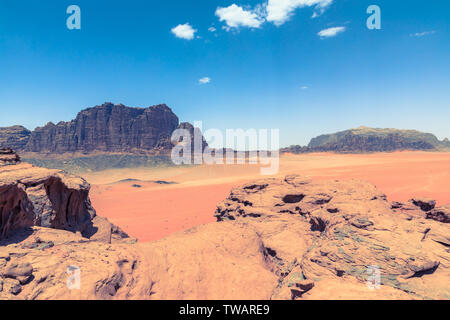 Roter Sand, Wüste am sonnigen Sommertag in Wadi Rum, Jordanien. Naher Osten. UNESCO-Weltkulturerbe und ist wie das Tal des Mondes bekannt. Stockfoto