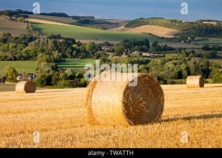 Strohballen auf dem Hügel über die Dörfer von Corton und Upton Lovell im Wylye Valley in Wiltshire. Stockfoto