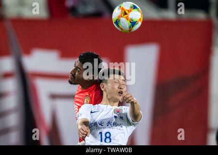 Brasilianische Fußballspieler Paulinho, top, der von China Guangzhou Evergrande Taobao F.C. leitet den Ball gegen einen Spieler von China Shandong Luneng Taishan F.C. in der achten - Finale der AFC Champions League 2019 in der Stadt Guangzhou, Provinz Guangdong im Süden Chinas, 18. Juni 2019. Dank der glücklichen Yang Sugs One des Gewinners, Guangzhou Evergrande beat Shandong Luneng 2-1 Im Hinspiel der AFC Champions League K.o.-Runde 1 hier am Dienstag. Stockfoto