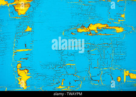 Peeling und Risse in blau und gelb lackierten Holz Hintergrund. Stockfoto