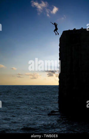 Eine junge Israeli arabischer Mann springen die Mauern der alten Stadt in das Mittelmeer in Akko oder Acre Norden Israels Stockfoto