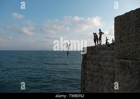 Eine junge Israeli arabischer Mann springen die Mauern der alten Stadt in das Mittelmeer in Akko oder Acre Norden Israels Stockfoto