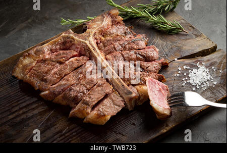 Zu steak wird gegrillt und auf einem Stück Holzplatte geschnitten. rustikalen Stil, Ansicht von oben Stockfoto