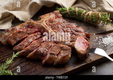 Zu Steak vom Grill ist auf ein Stück Holz Brett. rustikalen Stil geschnitten, Ansicht von oben Stockfoto