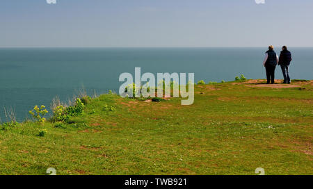 Ein paar mit Blick auf das Meer von einem exponierten Landspitze. Stockfoto