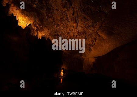 Eine weibliche Touristen Glow suchen Worms Im Waipu Caves, Waipu, North Island, Neuseeland Stockfoto