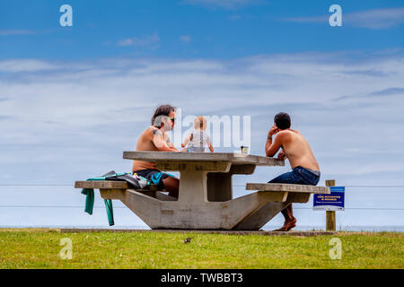 Die Leute an den Tischen am Strand, waipu Cove, Bream Bay, North Island, Neuseeland Sitzen Stockfoto