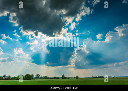 Cumulus Sturmwolken mit Licht Strahlen über den Himmel läuft Stockfoto